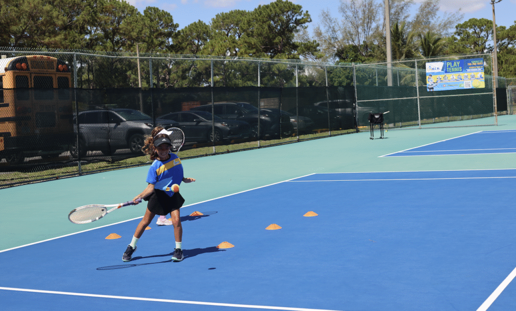 Girl happily playing in a kids tennis class in Miami
